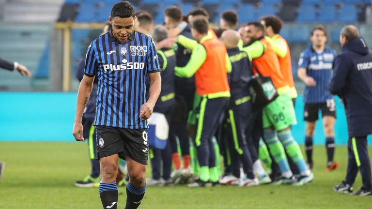 Atalanta's Luis Muriel leaves the field as Lazio players celebrate their victory