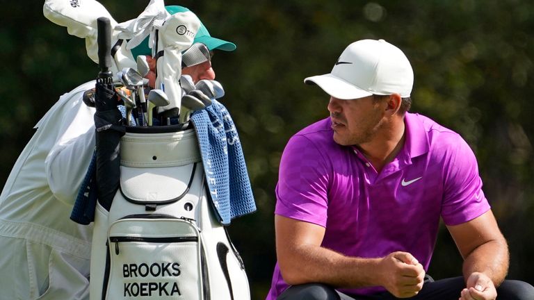 Brooks Koepka talks to his caddie Ricky Elliott before playing on the 11th hole during the final round of the Masters golf tournament Sunday, Nov. 15, 2020, in Augusta, Ga. (AP Photo/David J. Phillip)