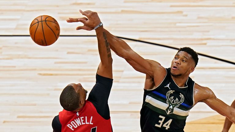 Milwaukee Bucks forward Giannis Antetokounmpo knocks a rebound away from Toronto Raptors guard Norman Powell