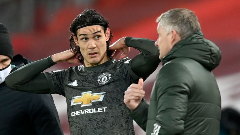 Manchester United's manager Ole Gunnar Solskjaer talks with Manchester United's Edinson Cavani during the English Premier League soccer match between Liverpool and Manchester United at Anfield Stadium, Liverpool, England, Sunday, Jan. 17, 2021. (Michael Regan/Pool via AP)
