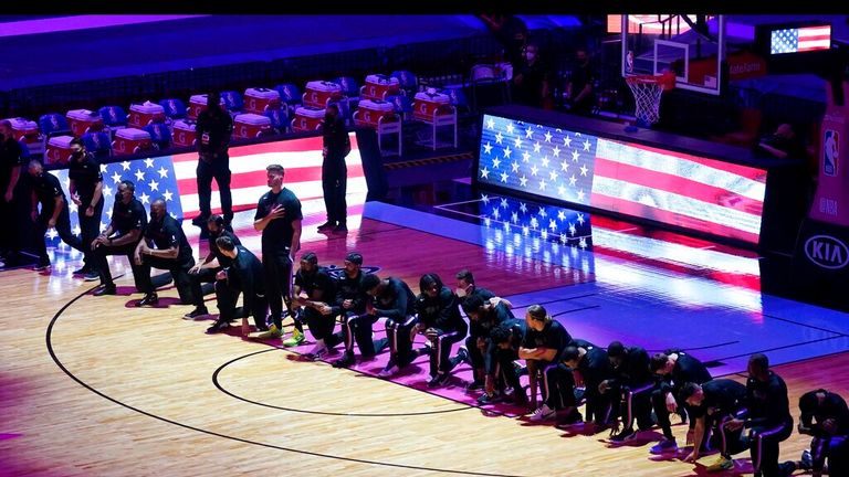AP - The Boston Celtics team kneels during the playing of the National Anthem before the first half of an NBA basketball game against the Miami Heat