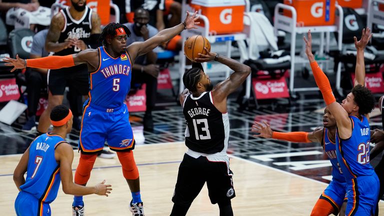Los Angeles Clippers guard Paul George (13) shoots between Oklahoma City Thunder players, including forward Luguentz Dort (5), during the fourth quarter of an NBA basketball game Friday, Jan. 22, 2021, in Los Angeles. (AP Photo/Ashley Landis)



