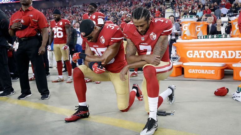 San Francisco quarterback Colin Kaepernick (right) kneels during the national anthem before an NFL football game against the Los Angeles Rams