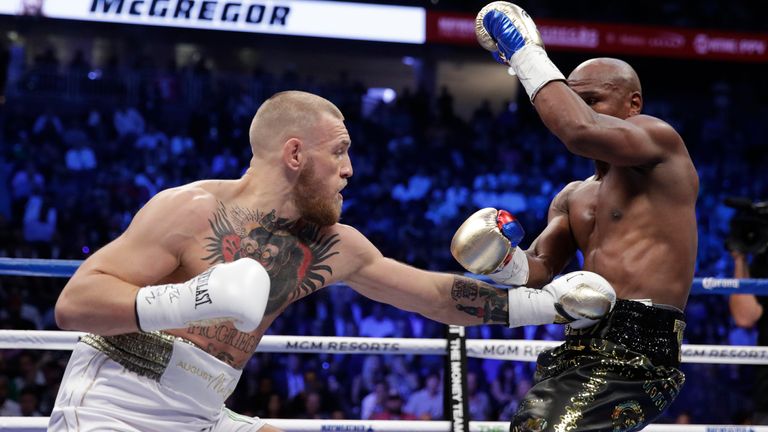 Conor McGregor hits Floyd Mayweather Jr. in a super welterweight boxing match Saturday, Aug. 26, 2017, in Las Vegas. (AP Photo/Isaac Brekken)  