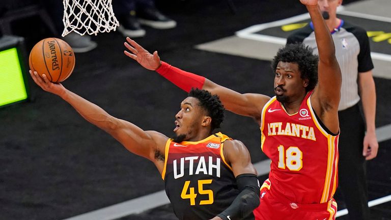 Utah Jazz guard Donovan Mitchell (45) lays the ball up as Atlanta Hawks forward Solomon Hill (18) defends during the first half of an NBA basketball game