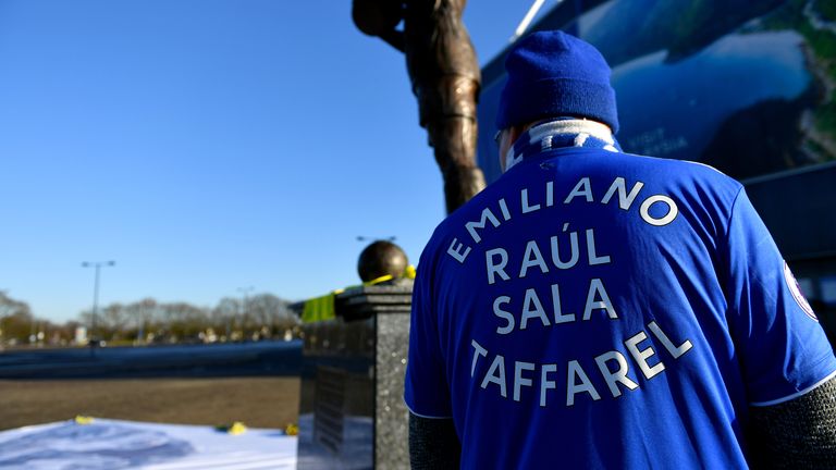 A fan wearing an Emliano Sala shirt looks at tributes at the Cardiff City Stadium