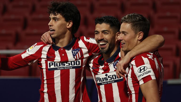 Luis Suarez of Atletico Madrid celebrates with his team-mates Joao Felix (L) and Marcos Llorente (R) after scoring against Valencia