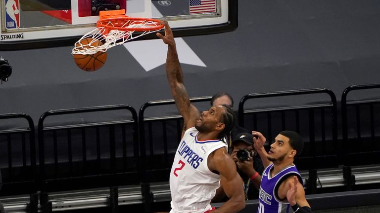 Los Angeles Clippers forward Kawhi Leonard dunks past Sacramento Kings guard Justin James, right, during the second half of an NBA basketball game