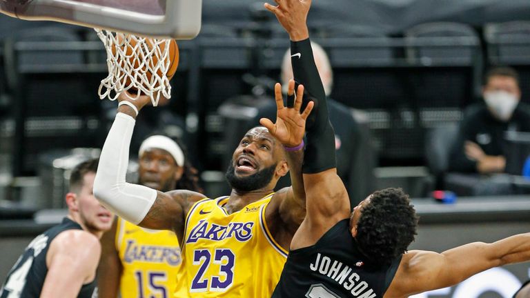 LeBron James #23 of the Los Angeles Lakers drives past Keldon Johnson #3 of the San Antonio Spurs #3 during second half action at AT&T Center