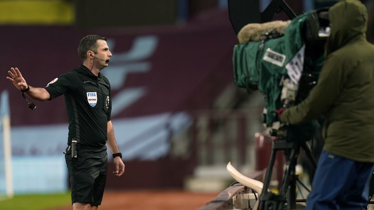 Michael Oliver reviews a decision using the VAR pitch-side monitor