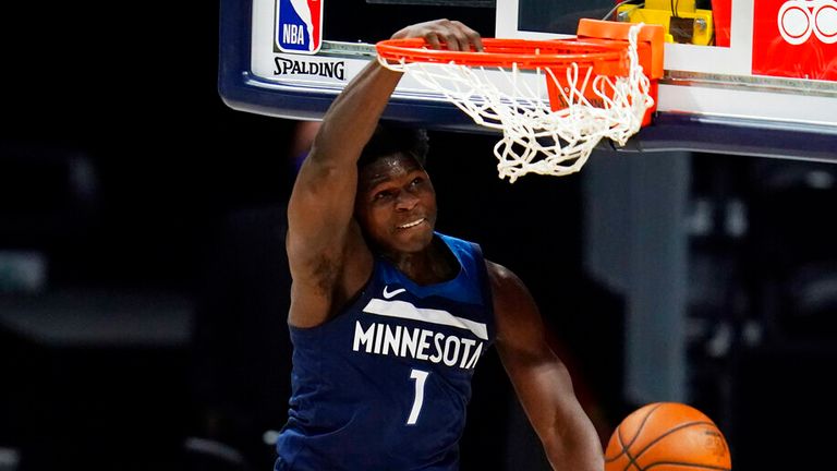AP - Minnesota Timberwolves guard Anthony Edwards (1) hangs from the rim after dunking the ball for a basket over Denver Nuggets center Nikola Jokic
