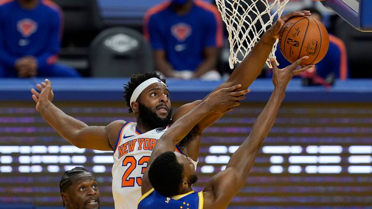 New York Knicks center Mitchell Robinson defends a shot by Golden State Warriors forward Andrew Wiggins during the second half of an NBA basketball game in San Francisco