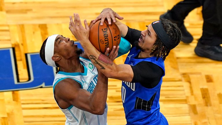 Orlando Magic guard Cole Anthony, right, forces a jump ball as Charlotte Hornets guard Devonte&#39; Graham, left, attempts a shot during the first half of an NBA basketball game, Sunday, Jan. 24, 2021, in Orlando, Fla.