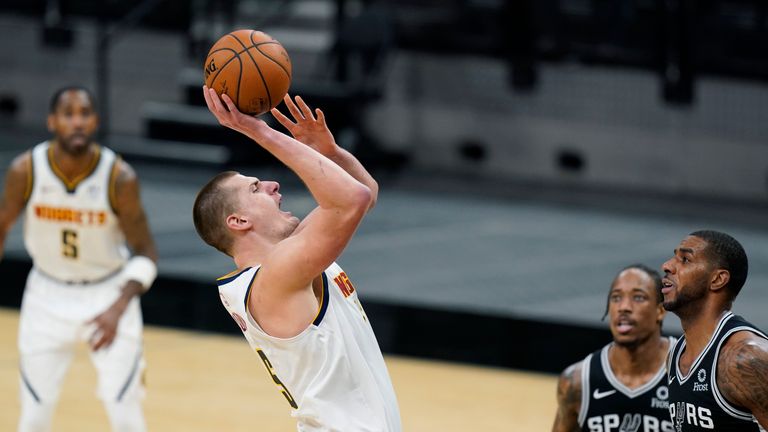 Denver Nuggets center Nikola Jokic (15) shoots over San Antonio Spurs forward DeMar DeRozan (10) and center LaMarcus Aldridge (12) during the second half of an NBA basketball game in San Antonio, Friday, Jan. 29, 2021. (AP Photo/Eric Gay)


