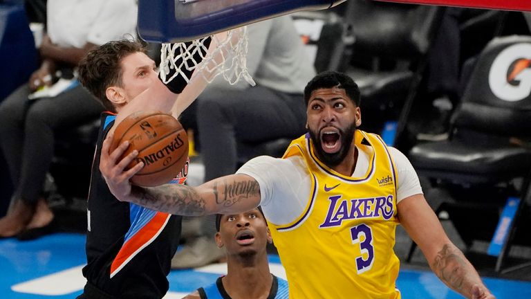 Los Angeles Lakers forward Anthony Davis (3) goes to the basket in front of Oklahoma City Thunder center Mike Muscala, left, and guard Shai Gilgeous-Alexander during the second half of an NBA basketball game Wednesday, Jan. 13, 2021, in Oklahoma City. (AP Photo/Sue Ogrocki)


