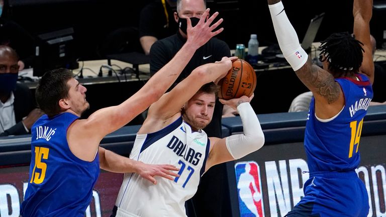 Dallas Mavericks guard Luka Doncic (77) is pressured by Denver Nuggets center Nikola Jokic (15) and guard Gary Harris (14) during the first quarter of an NBA basketball game Thursday, Jan. 7, 2021, in Denver. (AP Photo/Jack Dempsey)


