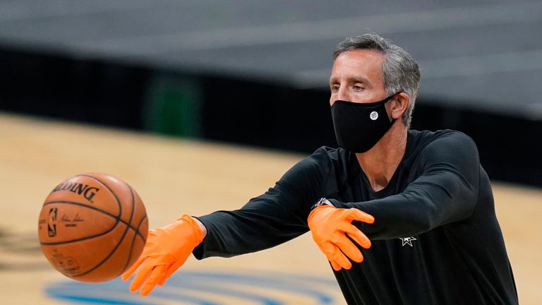 San Antonio Spurs assistant coach Chip Engelland wears a face mask and gloves to protect against the spread of COVID-19 as he helps the team warm up prior to an NBA basketball game against the Los Angeles Lakers in San Antonio, Wednesday, Dec. 30, 2020. (AP Photo/Eric Gay)


