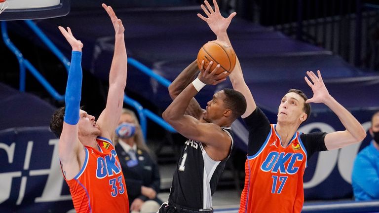 San Antonio Spurs guard Lonnie Walker IV (1) goes up for a shot between Oklahoma City Thunder center Mike Muscala (33) and forward Aleksej Pokusevski (17) in the second half of an NBA basketball game Tuesday, Jan. 12, 2021, in Oklahoma City. (AP Photo/Sue Ogrocki)



