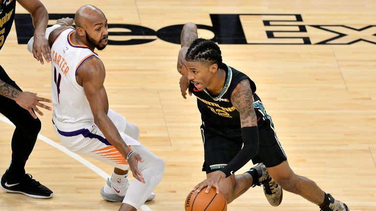 Memphis Grizzlies guard Ja Morant (12) drives against Phoenix Suns guard Jevon Carter (4) in the first half of an NBA basketball game Monday, Jan. 18, 2021, in Memphis, Tenn. (AP Photo/Brandon Dill)


