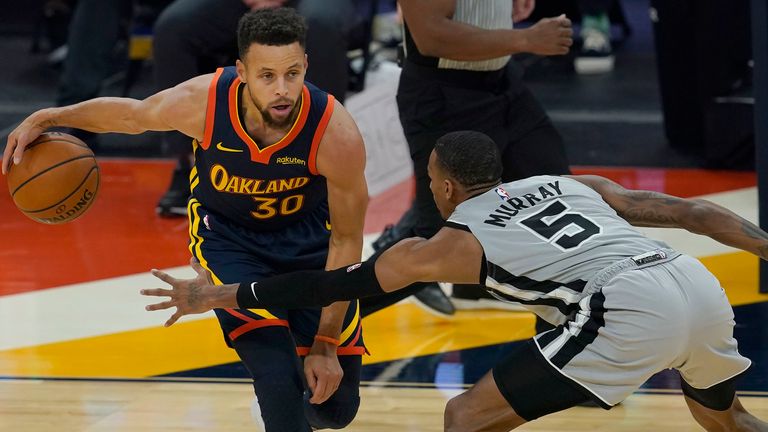 Golden State Warriors guard Stephen Curry (30) is defended by San Antonio Spurs guard Dejounte Murray (5) during the first half of an NBA basketball game in San Francisco, Wednesday, Jan. 20, 2021.