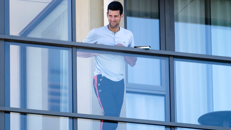 Serbia's Novak Djokovic stands on the balcony at his accommodation in Adelaide, Australia, Tuesday, Jan. 19, 2021. Australian Open tournament director Craig Tiley defended Djokovic for appealing to Australian Open organizers to ease restrictions so players could move to private residences with tennis courts. (Morgan Sette/AAP Image via AP)