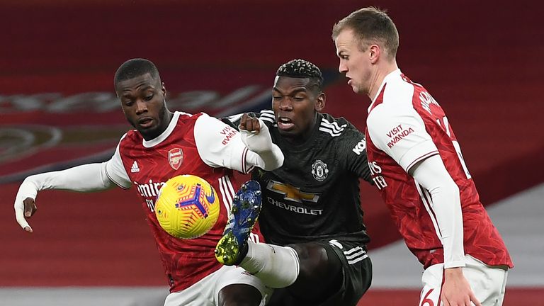 Paul Pogba is challenged by Arsenal&#39;s Nicolas Pepe and Rob Holding (AP)