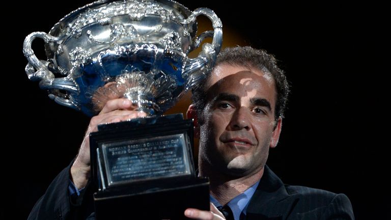 Former world No.1 Pete Sampras carries the championship trophy onto the Rod Laver Arena prior to the the men's singles final between Rafael Nadal of Spain and Stanislas Wawrinka of Switzerland at the Australian Open tennis championship in Melbourne, Australia, Sunday, Jan. 26, 2014.(AP Photo/Andrew Brownbill)