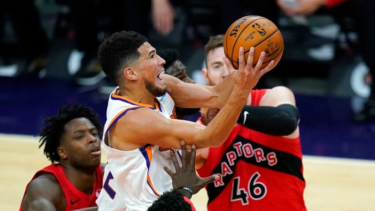 AP - Phoenix Suns guard Devin Booker, middle, drives past Toronto Raptors center Aron Baynes (46) and Raptors forward OG Anunoby