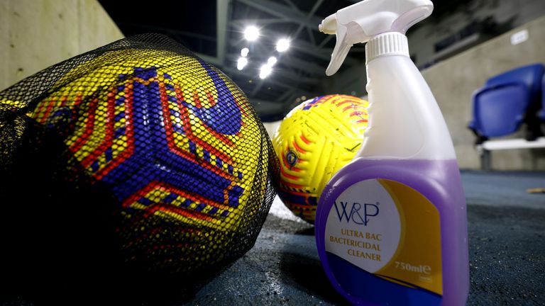 Premier League balls next to disinfectant spray