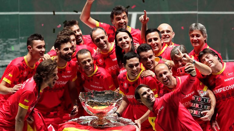 Spain's Rafael Nadal, foreground, takes a selfie with fellow players and team staff posing with the trophy after Spain defeated Canada 2-0 to win the Davis Cup final in Madrid, Spain, Sunday, Nov. 24, 2019. (AP Photo/Bernat Armangue)
