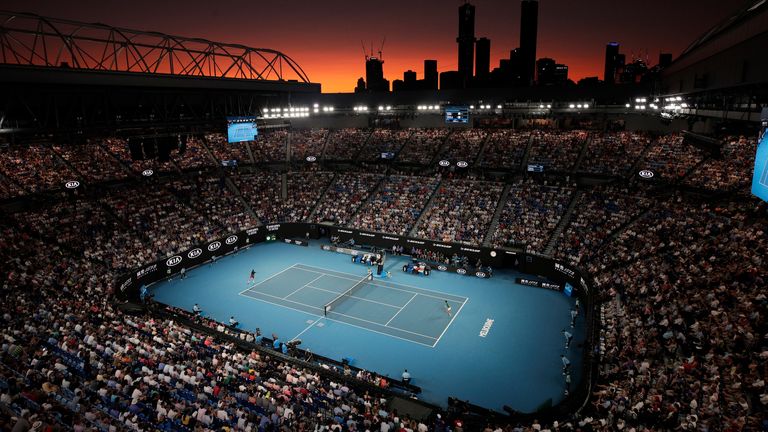 Switzerland's Roger Federer and Serbia's Novak Djokovic play their semifinal match on Rod Laver Arena as the sun sets at the Australian Open tennis championship in Melbourne, Australia, on Jan. 30, 2020. (AP Photo/Andy Wong)       