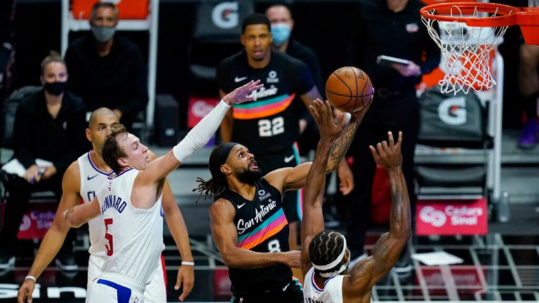 AP - San Antonio Spurs guard Patty Mills (8) shoots next to Los Angeles Clippers forward Nicolas Batum (5) and forward Kawhi Leonard (2) during the fourth quarter of an NBA basketball game