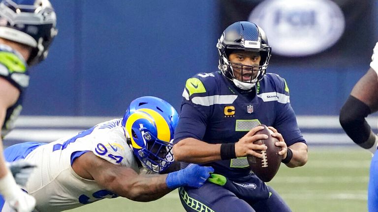 AP - Seattle Seahawks quarterback Russell Wilson, right, eyes a receiver as Los Angeles Rams defensive tackle A'Shawn Robinson grabs him during the second half 