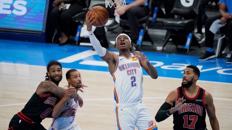 Oklahoma City Thunder guard Shai Gilgeous-Alexander (2) shoots between Chicago Bulls guards Coby White (0) and Garrett Temple (17) and Thunder's George Hill (3) during the second half of an NBA basketball game