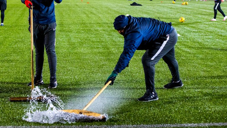 SNS - Ground staff sweep rain off the pitch ahead of the postponed Scottish Premiership match between Livingston and Aberdeen at the Tony Macaroni Arena