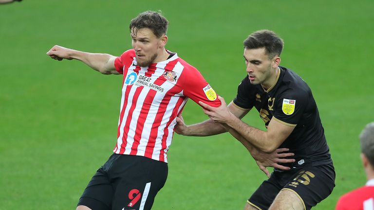 Sunderland's Charlie Wyke (left) and Milton Keynes Dons' Warren O'Hora battle for the ball during the Sky Bet League One match at the Stadium of Light, Sunderland.