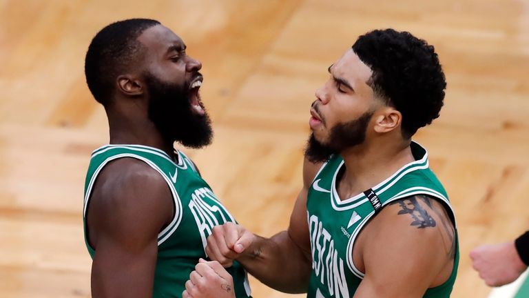 Boston Celtics' Jayson Tatum celebrates with Jaylen Brown after making the go-ahead basket with less than a second on the clock during the second half of an NBA basketball game against the Milwaukee Bucks