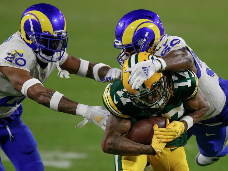 Aaron Jones of the Green Bay Packers avoids a tackle by Troy Hill