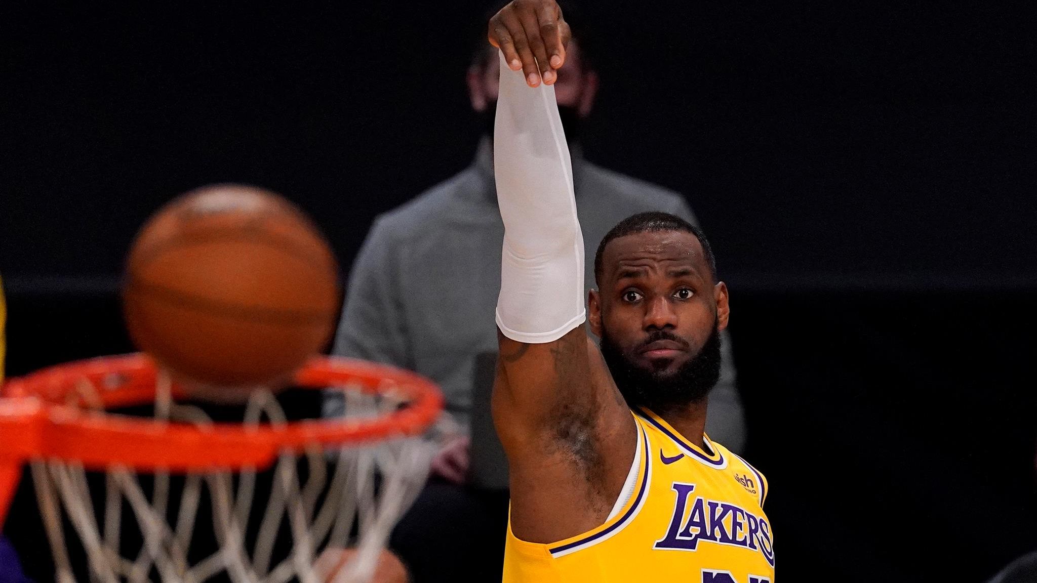 Los Angeles Lakers forward LeBron James, right, dunks past Charlotte Hornets  guard LaMelo Ball (2) during the first half of an NBA basketball game  Thursday, March 18, 2021, in Los Angeles. (AP