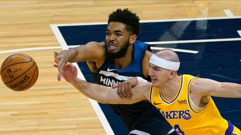 Minnesota Timberwolves&#39; Karl-Anthony Towns, left, and Los Angeles Lakers&#39; Alex Caruso battle for the ball in the first half of an NBA basketball game, Tuesday, Feb. 16, 2021, in Minneapolis.