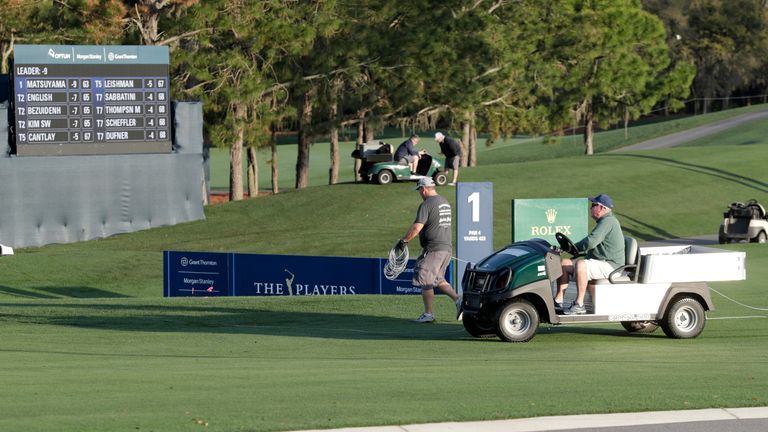 Grounds crew workers clear the course after the PGA Tour cancelled the rest of The Players Championship golf tournament as a result of the coronavirus pandemic