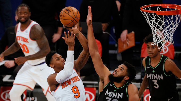 RJ Barrett of the New York Knicks shoots as Karl-Anthony Towns of the Minnesota Timberwolves defends