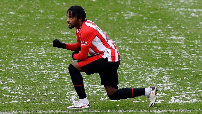 Leicester's Cengiz Under, left, and Brentford's Tariqe Fosu take a knee before the start of the English FA Cup fourth round soccer match between Brentford FC and Leicester City at Brentford Community stadium in London, Sunday, Jan. 24, 2021. (AP Photo/Kirsty Wigglesworth)