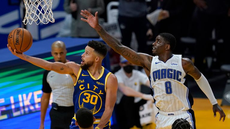 Golden State Warriors guard Stephen Curry shoots in front of Orlando Magic forward Dwayne Bacon