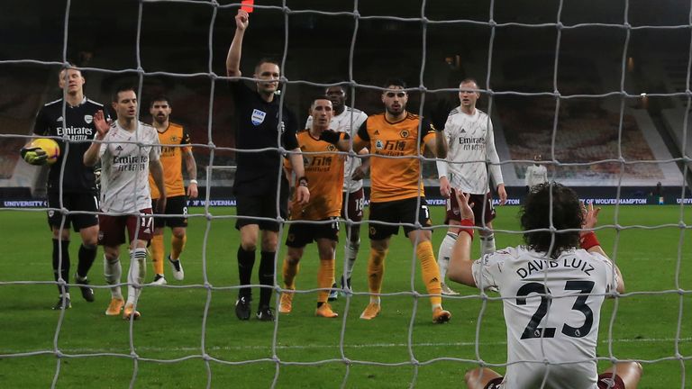 Referee Craig Pawson brandishes a red card to David Luiz on Tuesday night