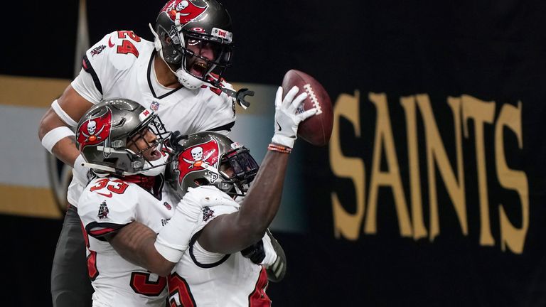 Tampa Bay Buccaneers inside linebacker Devin White, bottom right, celebrates after intercepting a pass with teammates Jordan Whitehead (33) and Carlton Davis (24) against the New Orleans Saints during the second half of an NFL divisional round playoff football game, Sunday, Jan. 17, 2021, in New Orleans. (AP Photo/Brynn Anderson)