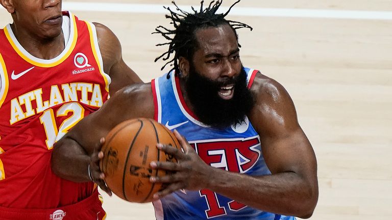 Brooklyn Nets&#39; James Harden (13) is defended by Atlanta Hawks&#39; De&#39;Andre Hunter (12) during the first half of an NBA basketball game Wednesday, Jan. 27, 2021, in Atlanta. 