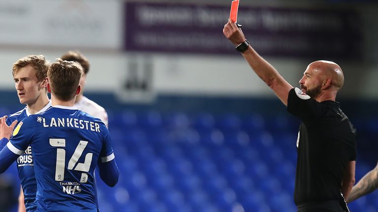 Flynn Downes of Ipswich Town is shown a red card by referee Darren Drysdale against Northampton