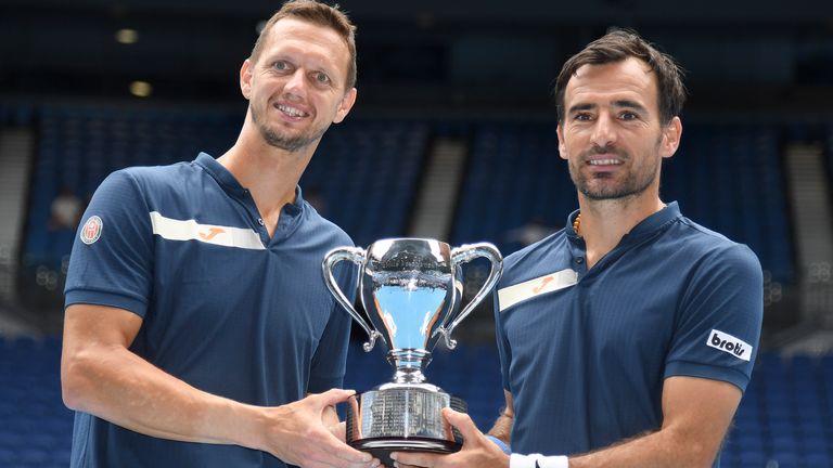 Croatia's Ivan Dodig, right, and Slovakia's Filip Polasek pose with their trophy after defeating Rajeev Ram of the US and Britain's Joe Salisbury in the men's doubles final at the Australian Open tennis championship in Melbourne, Australia, Sunday, Feb. 21, 2021.(AP Photo/Andy Brownbill)
