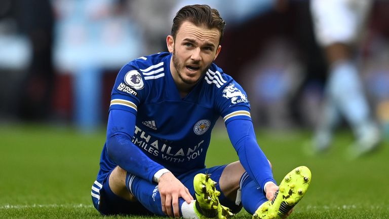 James Maddison holds his foot as he sits injured